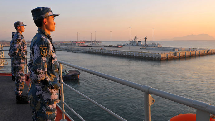 Chinese naval soldiers stand guard on China's first aircraft carrier Liaoning, as it travels towards a military base in Sanya, Hainan province, in this undated picture made available on November 30, 2013.(Reuters / Stringer)