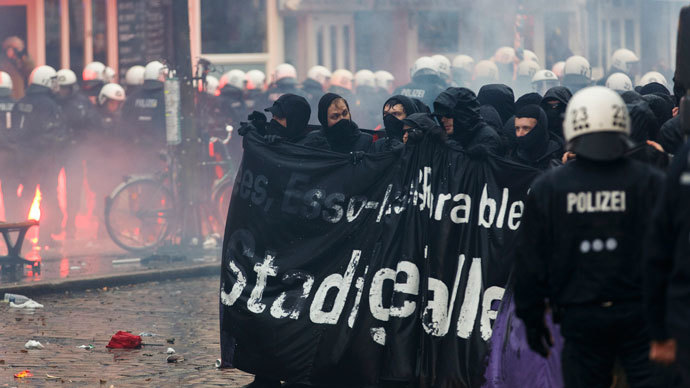 Protesters hold up a banner during clashes in front of the 'Rote Flora' cultural centre during a demonstration in Hamburg, December 21, 2013. (Reuters / Morris Mac Matzen)