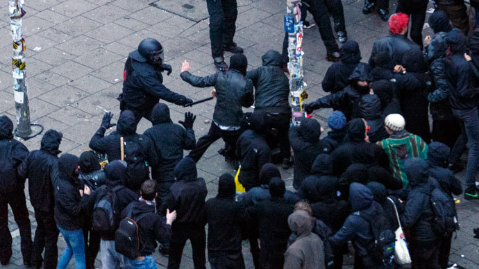 A German riot police officer uses his baton during clashes in front of the 'Rote Flora' cultural centre during a demonstration in Hamburg, December 21, 2013.(Reuters / Morris Mac Matzen)