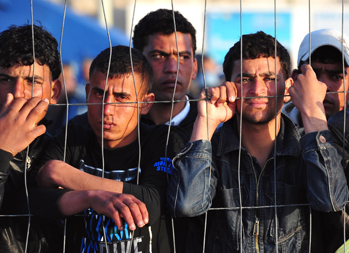 Tunisian migrants wait for the arrival of boats at Lampedusa on March 27, 2011. (AFP Photo/Alberto Pizzoli)