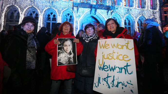 People hold signs after a march from Brussels to Mons in support of the Afghans refugees, organized by the Afghan Collective in Mons on December 22, 2013.( AFP Photo / Nicolas Maeterlinck)