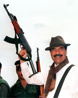 Saddam Hussein brandishing a Russian-made AK 47 assault rifle during his visit to villages in northern Iraq. (AFP)