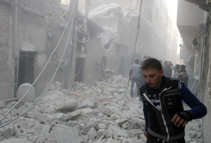 People stand on the rubble of damaged buildings after what activists said was an air raid by forces loyal to Syrian President Bashar Al-Assad, in Aleppo's al-Saliheen district December 23, 2013. (Reuters/Saad AboBrahim)