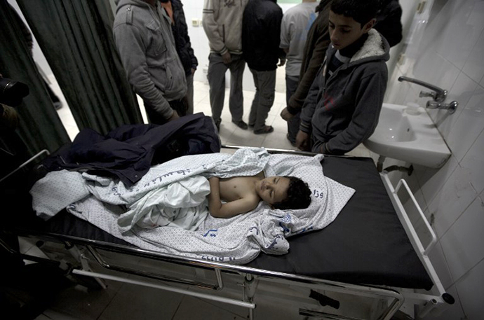 The brother of killed three-year-old Palestinian girl Hala Abu Sabikha, lies on a hospital trolley in Deir al-Balah, in the central Gaza Strip, on December 24, 2013. (AFP Photo / Mahmud Hams)