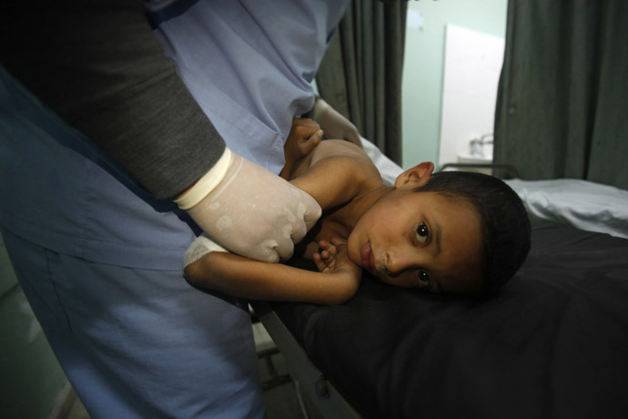 A Palestinian boy, who medics said was wounded during an Israeli air strike on the Bureij facility, lies on a bed at a hospital in the central Gaza Strip December 24, 2013. (Reuters/Ibraheem Abu Mustafa)