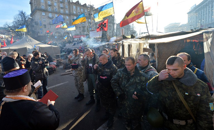 Ukrainian cossaks cross themself during a service before taking their guarding duty at the camp of the pro-EU opposition at Kiev's Independence Square on December 24, 2013. (AFP Photo / Sergei Supinsky)