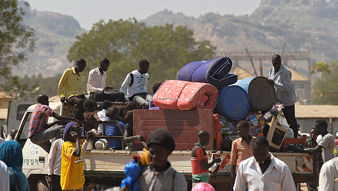 Residents of Juba with their belongings pile onto a truck heading out of the city on December 21, 2013 where tension remains high fueling an exodus of both local and foreign residents from the south Sudanese capital. (AFP Photo / Tony Karumba)