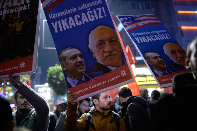 A Turkish protester holds up a placard with pictures of Turkish Prime Minister Recep Tayyip Erdogan (L) and the United States-based Turkish cleric Fethullah Gulen reading "We will cast them down" during a demonstration against corruption in the Kadikoy district of Istanbul on December 25, 2013 (AFP Photo / Bulent Kilic)