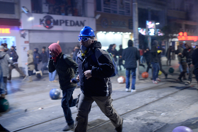 Demonstrators run away as they clash with riot police (unseen) during a protest against corruption in the Kadikoy district of Istanbul on December 25, 2013 (AFP Photo / Bulent Kilic)