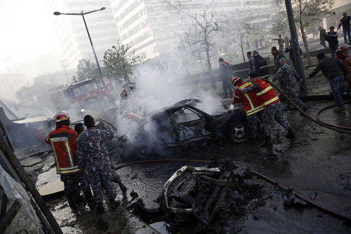Civil Defence personnel extinguish fires on cars at the site of an explosion in Beirut downtown area December 27, 2013. (Reuters/Steve Crisp)