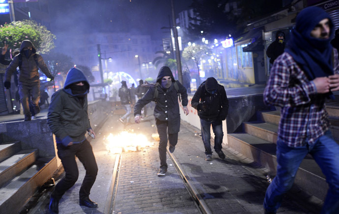 Demonstrators run away as they clash with riot police (unseen) during a protest against corruption in the Kadikoy district of Istanbul on December 25, 2013. (AFP Photo/Bulent Kilic)