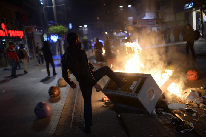 A man helps build a barricade as demonstrators clash with riot police (unseen) during a protest against corruption in the Kadikoy district of Istanbul on December 25, 2013. (AFP Photo/Bulent Kilic)
