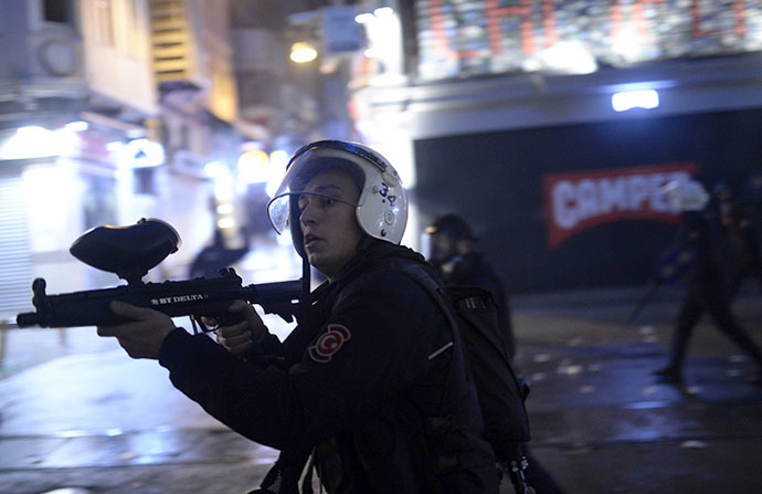 Turkish policemen fire rubber bullets against protestors on the Istiklal Avenue on December 27, 2013, during clashes between the Turkish police and protestors. (AFP Photo / Bulent Kilic)