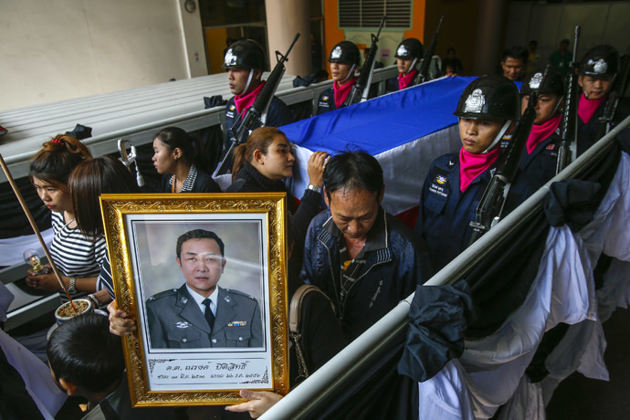Relatives and mourners lead a procession to a temple for the funeral ceremony of Narong Pitisitthi, 45, a policeman who died after being shot during the clashes between anti-government protesters and riot police, at the police hospital in Bangkok December 27, 2013. (Reuters/Athit Perawongmetha)