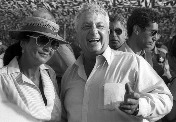 Ariel Sharon laughs as his wife Lily stands at his side during an aerial display in an Israeli Air Force Base July 15, 1982 in this handout photo released by the Government Press Office. (Reuters/Baruch Rimon/Government Press Office)
