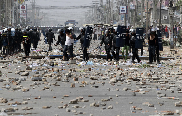 Workers are detained by riot police officers after clashes broke out during a protest in Phnom Penh January 3, 2014. (Reuters/Samrang Pring)