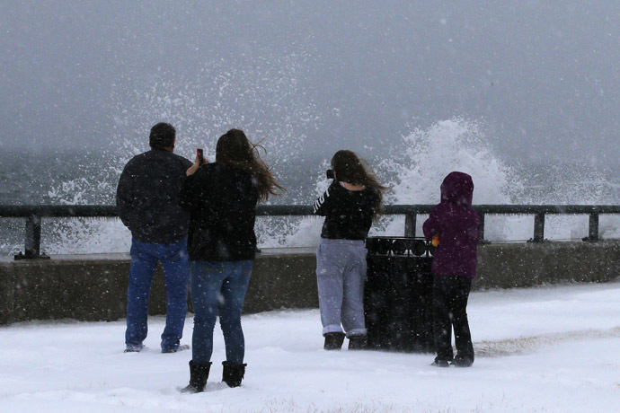 Onlookers look at waves crashing against the seawall around high tide during a winter nor'easter snowstorm in Lynn, Massachusetts January 2, 2014. (Reuters/Brian Snyder)