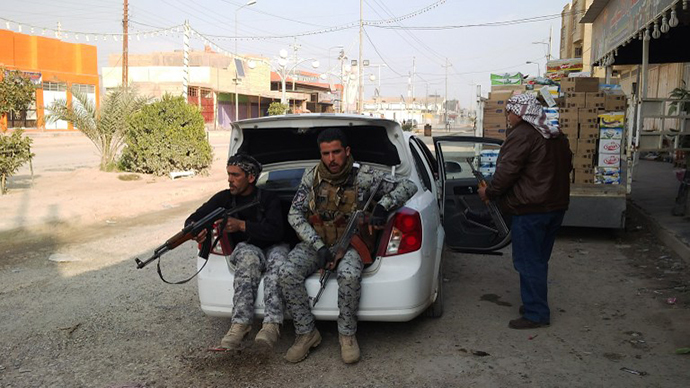 Armed tribesmen and Iraqi police sit in a car as clashes rage on in the Iraqi city of Ramadi, west of Baghdad, on January 2, 2014. (AFP Photo / Azhar Shallal)