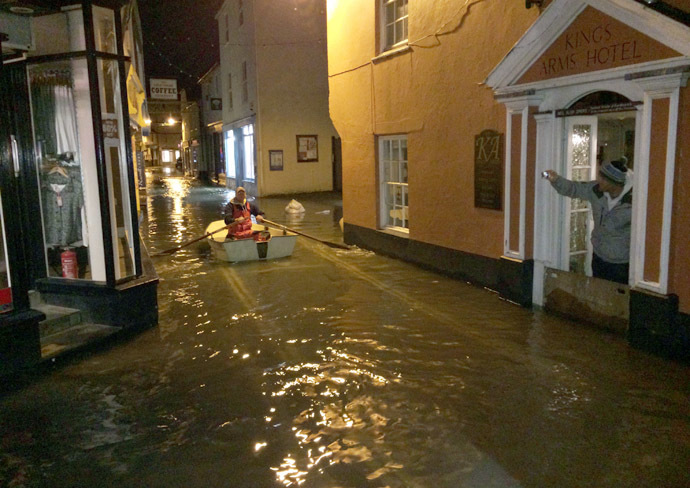 This handout picture received from the Royal National Lifeboat Institution (RNLI) on January 3, 2014 shows a man rowing a boat down the flooded main street following a high tide at Salcombe in Devon, southwest England. (AFP/RNLI)