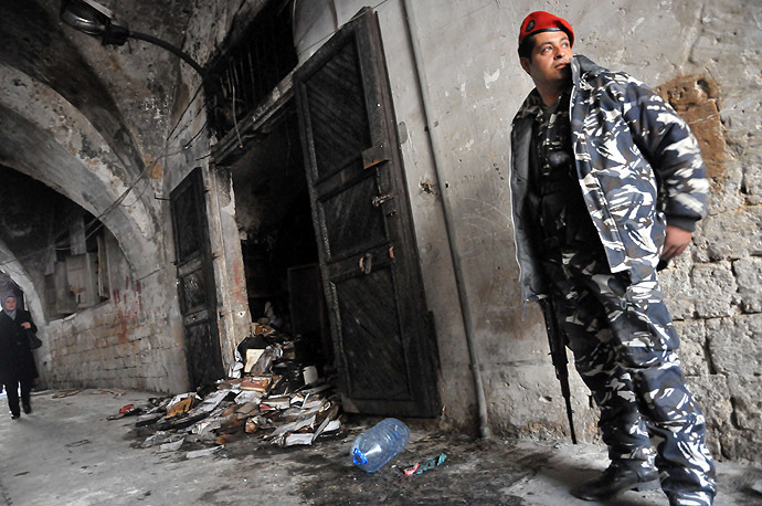 A Lebanese soldier stands guard, on January 4, 2014 in north Lebanon's city of Tripoli, outside a decades-old library owned by a Greek Orthodox priest that was torched after "a pamphlet was discovered inside one of the books that was insulting to Islam and the prophet Mohammad" said a source, who spoke to AFP on condition of anonymity. (AFP Photo)