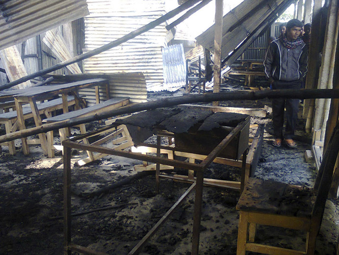 People look at a primary school which was supposed to be used as a polling booth after it was set on fire, in Rajshahi January 4, 2014. (Reuters)