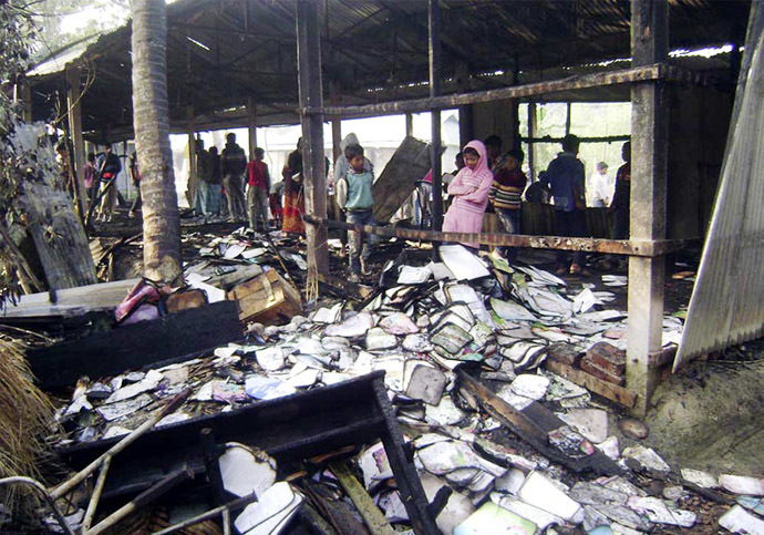 People look at burnt textbooks after a primary school which was supposed to be used as a polling booth was set on fire, in Feni January 4, 2014. (Reuters)