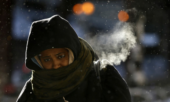 A woman walks in frigid cold temperatures though downtown Chicago, Illinois, January 6, 2014. (Reuters/Jim Young)