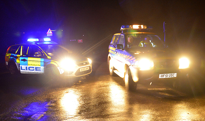 Emergency vehicles drive past a police road-block in the village of Cley in Norfolk, east England, January 8, 2014. (Reuters / Toby Melville)