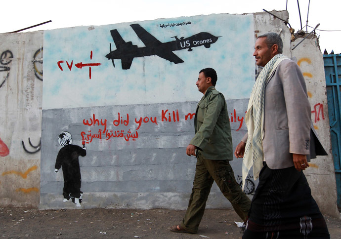 Yemeni men walk past a mural depicting a US drone and reading " Why did you kill my family" on December 13, 2013 in the capital Sanaa. (AFP Photo)