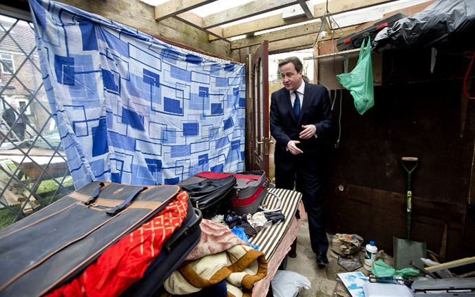 Britain's Prime Minister David Cameron is shown around a house in Southall in London on December 18, 2013 which was raided earlier in the day by immigration officers. (AFP Photo / David Bebber)