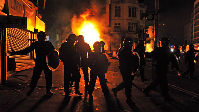 British riot policemen stand in front of a burning building in Croydon.(AFP Photo / Carl De Souza)