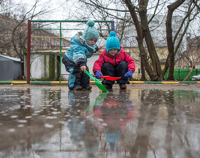 Children playing in a puddle in a courtyard on January 10, 2014. Abnormally warm weather has settled in Moscow. (RIA Novosti / Iliya Pitalev)