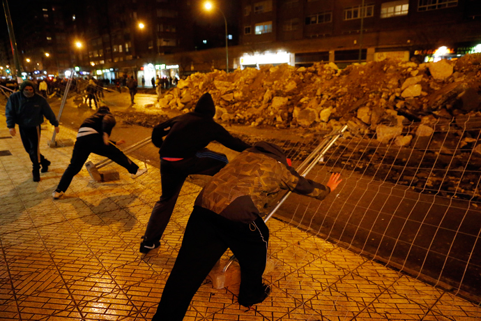 Demonstrators push down fencing in protest against imminent construction works to revamp Vitoria street, the city's main thorough-fare, in Burgos on January 12, 2014 (AFP Photo / Cesar Manso)