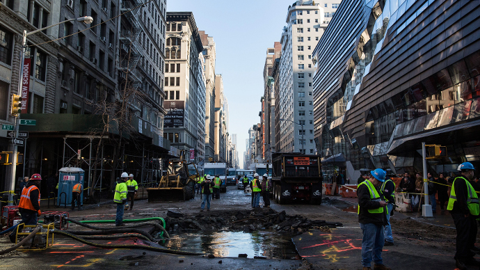 Workers monitor a hole caused by a water main break on 5th Ave and 13th St. on January 15, 2014 in New York City. (AFP Photo / Andrew Burton)