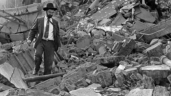 (FILE) A man walks over the rubble left after a bomb exploded at the Argentinian Israeli Mutual Association (AMIA in Spanish) in Buenos Aires, 18 July 1994. (AFP Photo / Ali Burafi)