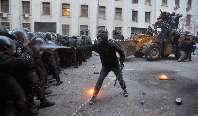 A protester uses tear gas against riot police during the storming of the Viktor Yanukovych Presidential office in Kiev during a mass rally of the opposition on December 1, 2013. (AFP Photo / Genya Savilov)