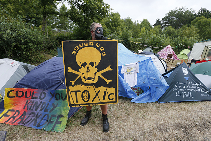 A demonstrator holds a placard at the protest camp, near the entrance to a site run by Cuadrilla Resources, near Balcombe in southern England August 16, 2013. (Reuters / Stefan Wermuth)