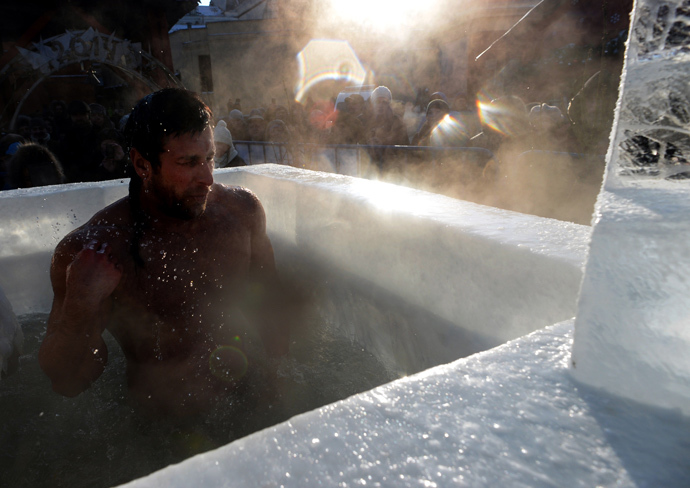 A Russian Orthodox man bathes in ice cold water near the Red Square in Moscow during a ceremony marking Epiphany on January 19, 2014. (AFP Photo / Vasily Maximov) 