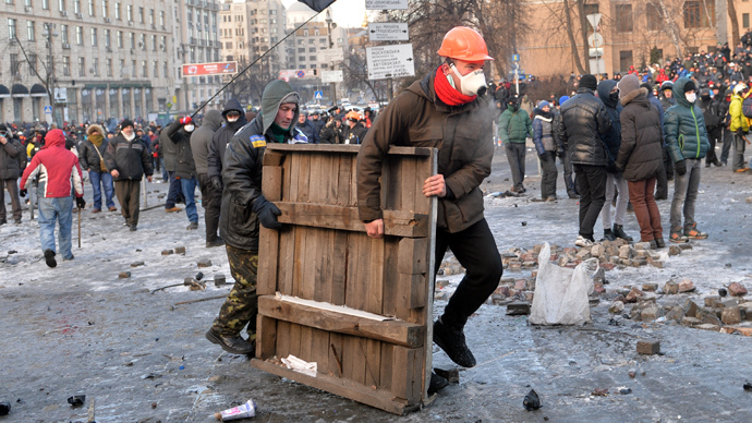 Protesters carry a wooden board to build barricades during clashes with the police in Kiev on January 20, 2014 (AFP Photo / Sergey Supinsky)