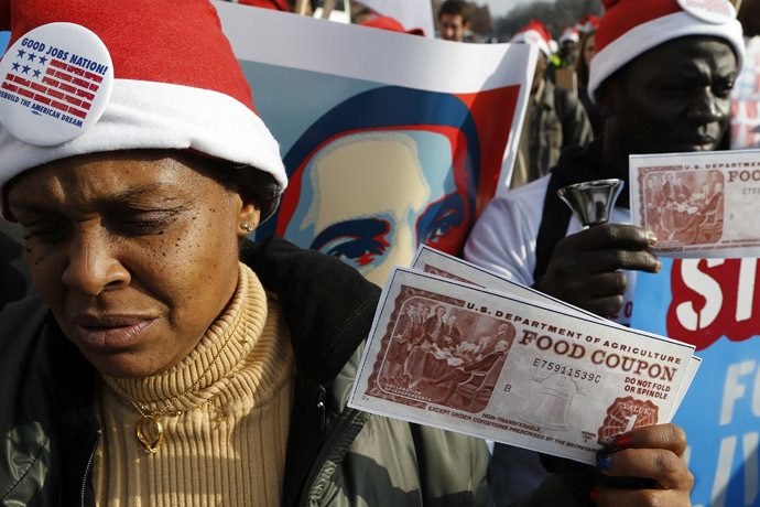 Protesters hold replicas of food stamps during a rally in support of higher pay for low-wage earners outside the National Air and Space Museum in Washington, December 5, 2013. (Reuters/Jonathan Ernst)