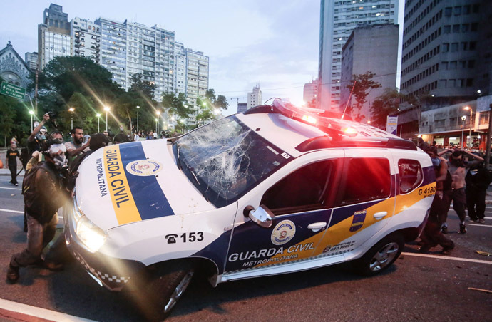 A civil guard car is attacked by demonstrators during the "Nao Vai Ter Copa" (You are not going to have Cup) protest along Consolacao Street, in Sao Paulo, Brazil, on January 25, 2014. (AFP Photo/Miguel Schincariol)