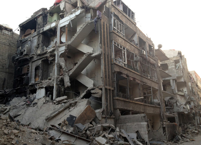 A general view shows a damaged building, sliced in half from top to bottom, in the Damascus suburb of Zamalka (Reuters)