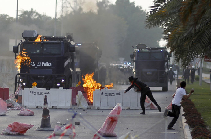An anti-government protester throws a Molotov cocktail at a riot-police armored personnel carrier during clashes after the funeral procession of Fadhel Abas Muslim in the village of Diraz, west of Manama, January 26, 2014. (Reuters/Hamad I Mohammed)