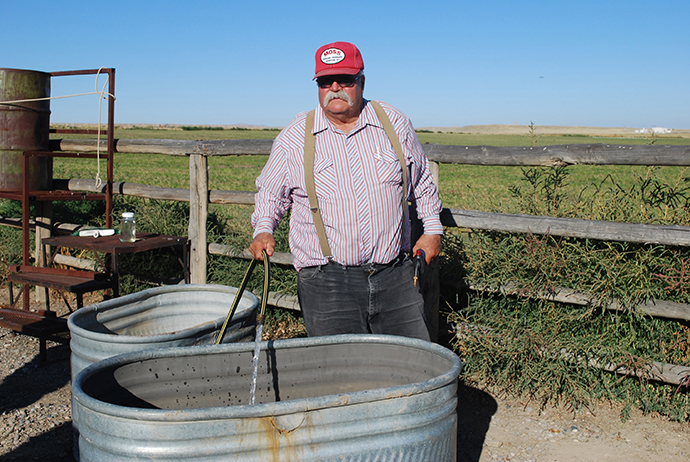 Louis Meeks, a farmer, fills a trough with contaminated water from his well. (Reuters / Jon Hurdle)