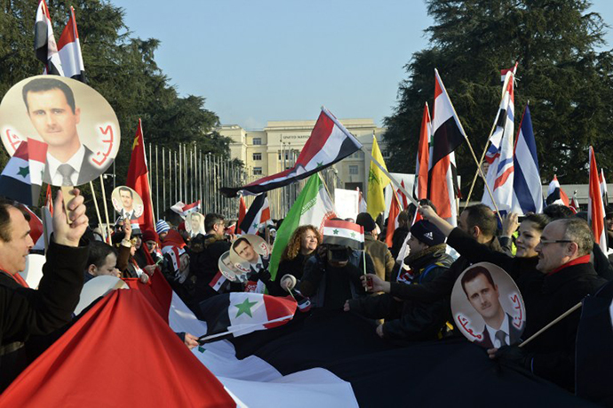 Pro-Syrian regime protesters, holding portraits of Syrian President Bashar al-Assad and waving Syrian flags take part to a demonstration in front of the United Nations headquarters in Geneva on January 31, 2014. (AFP Photo / Philippe Desmazes)