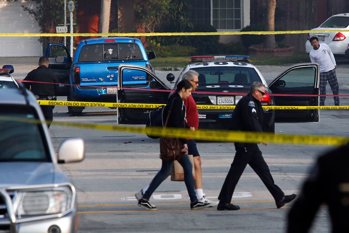 Bystanders are escorted from a crime scene while police detectives investigate a shooting incident involving a blue Toyota Tacoma pickup truck in Torrance, California, February 7, 2013.(Reuters / Patrick T. Fallon)