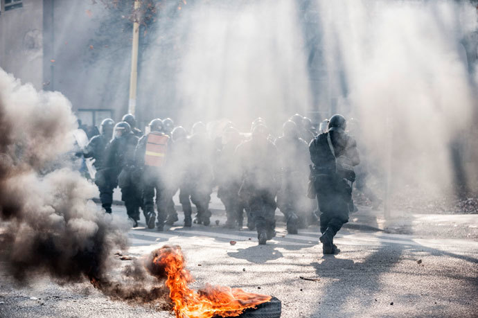 Smoke rises near the police as anti-government protesters hold a demonstration in Tuzla February 6, 2014.(Reuters / Edmond Ibrahimi)