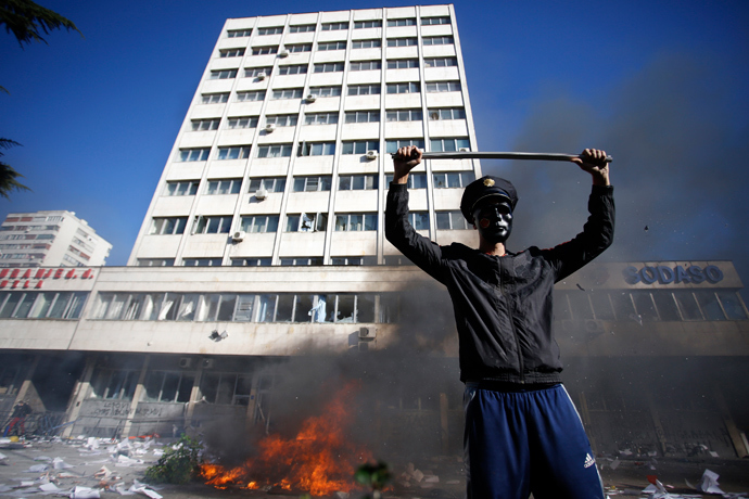 A protester stands near a fire set in front of a government building in Tuzla February 7, 2014. (Reuters / Dado Ruvic)