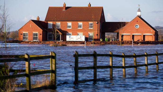 A new house is pictured with a barrier around it protecting it from flood waters in Moorland, some 19 Kms Northeast of Taunton on February 7, 2014 (AFP Photo / Justin Talli)
