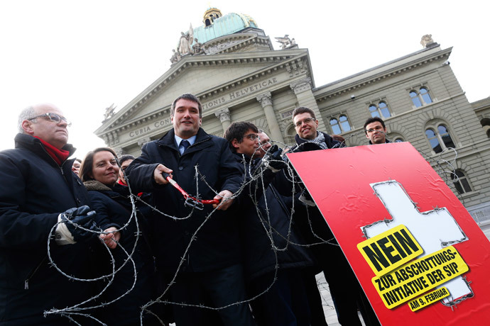 Parliament members and President of the Swiss Socalist Party SPS Christian Levrat (C) cuts a barbed wire fence on the Federal Square during a campaign in Bern January 29, 2014. (Reuters / Ruben Sprich) 